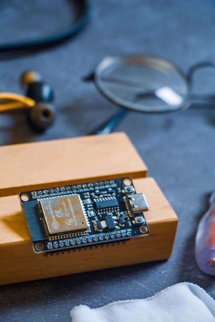 Close-up of a microcontroller on a wooden block, showcasing modern technology in Dhaka, Bangladesh.
